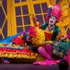 Opera singers wearing neon-colored costumes and wigs onstage.