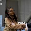 A Temple student shakes hands with a man wearing a suit at a university career fair.