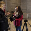 A student reporter talks with a source on the street.