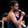 Jazz singer performing on stage with a band.